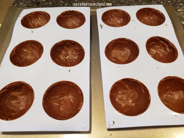 Twelve half-spheres are coated with chocolate twice, then refrigerated to set.