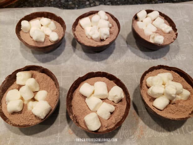 Half the chocolate spheres are filled with mini marshmallows and hot cocoa mix before being sealed.