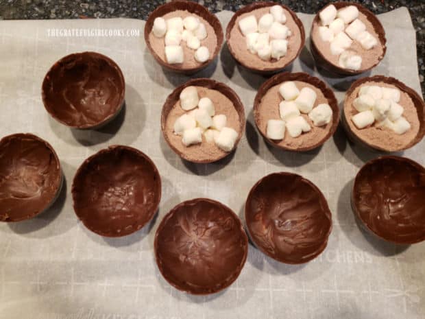 Half of the hot cocoa bombs are filled with cocoa mix and mini marshmallows before sealing closed.