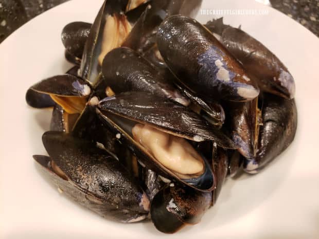 Cooked, opened mussels are placed in serving bowls and kept warm until sauce is made.