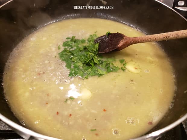 Chopped parsley is added to the hot wine garlic butter sauce in skillet.