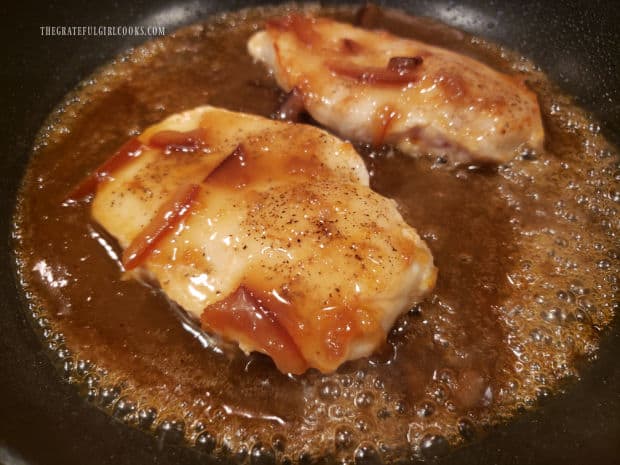 The orange Dijon sauce is added to the skillet with the browned chicken breasts.