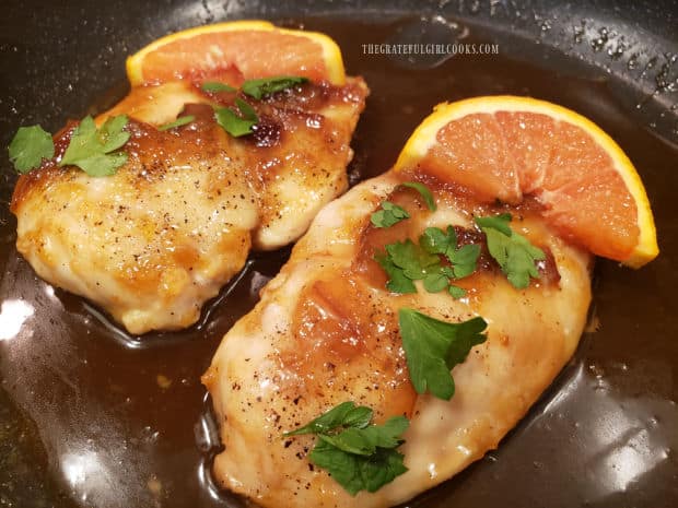 Orange Dijon Chicken Breasts are garnished with parsley and an orange slice for serving.