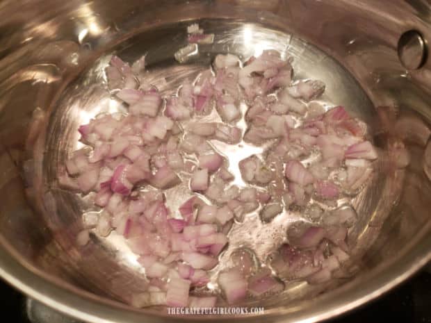 Chopped shallots cook in melted coconut oil in a small saucepan.