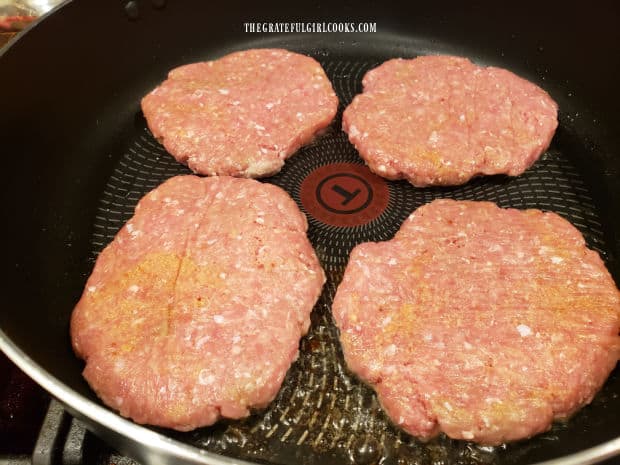 The turkey patties are pan-seared in hot oil in a large skillet.