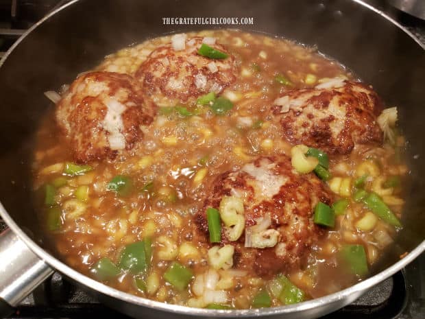 Celery, onion, and green bell pepper are added to the smothered turkey patties.