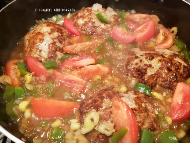 Fresh tomato wedges are added to the smothered turkey patties and heated through.