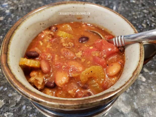 A soup mug holds a serving of the hot and tasty turkey chili, ready to eat.