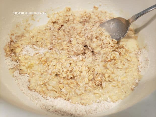 Dry ingredients are stirred into the rolled oat mixture, forming a thick batter.