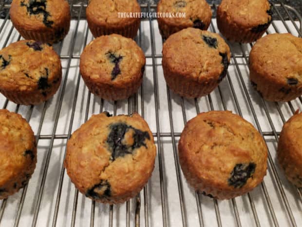 After baking, the blueberry oat muffins cool on a wire rack before glazing.