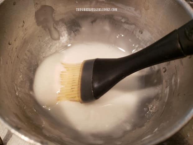 A thin glaze of powdered sugar and water is mixed to glaze the top of the baked muffins.