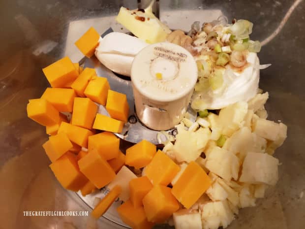 Ingredients for the cheddar jack cheese spread are placed into a food processor.