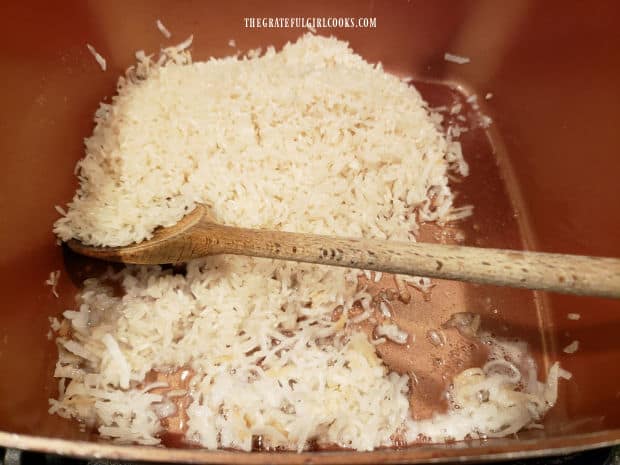 Jasmine rice is added to coconut oil and toasted coconut mixture in saucepan.