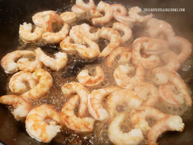 Shrimp are cooked in a cast iron skillet for only a few minutes.