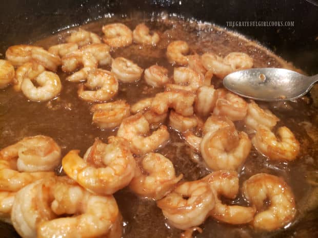 Honey garlic shrimp are covered in sauce and heated through before serving.