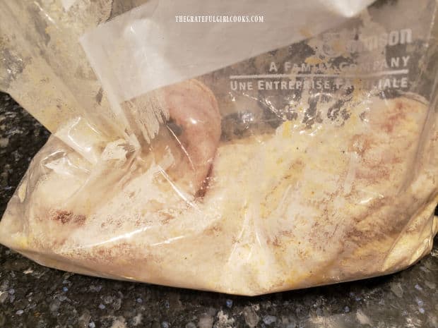 Fish fillets are placed into seasoning mix bag after being covered in egg wash.