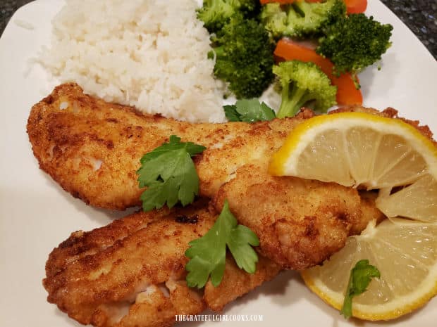 Krispy rockfish fillets are served, garnished with parsley and a lemon slice.