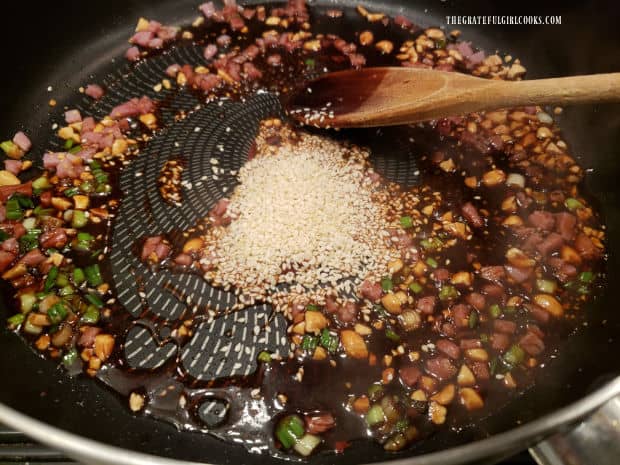 Sesame seeds are added to the Szechuan sauce in a large skillet.