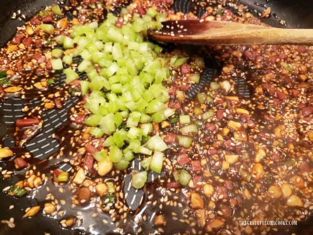 Chopped celery is added to the Szechuan sauce and cooked before noodles are added.