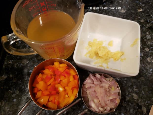 Chicken broth, ginger, red peppers and shallots ready to season the mussels.