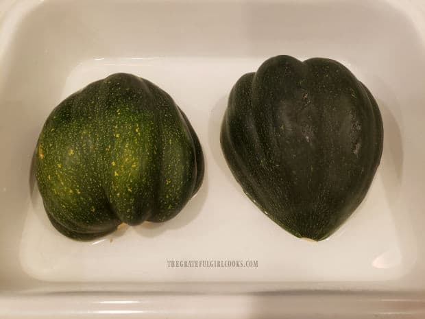Acorn squash halves are baked in 1/4" water in an oven-safe rimmed pan.