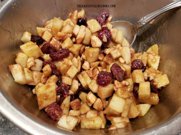 A filling with diced apples, cranberries, pecans, etc. is combined to fill acorn squash halves.