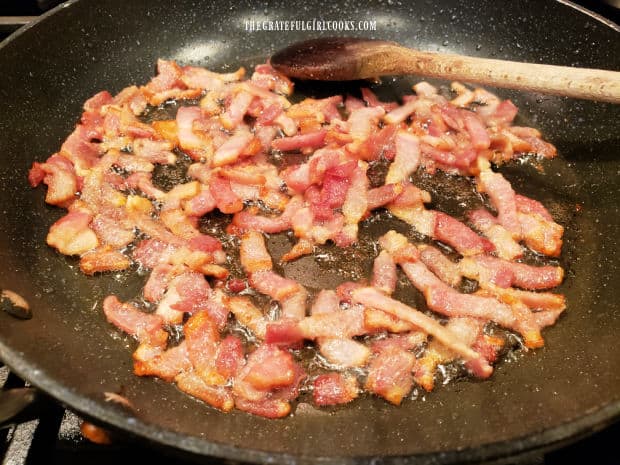 Strips of bacon are quickly cooked in a large skillet.