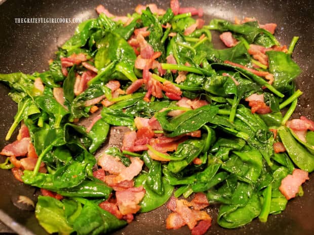 After cooking, the bacon and spinach will be removed from the pan to cool.