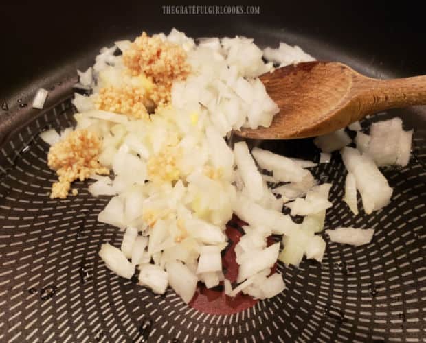 Chopped onions, garlic and grated ginger are cooked in hot oil in a large skillet.