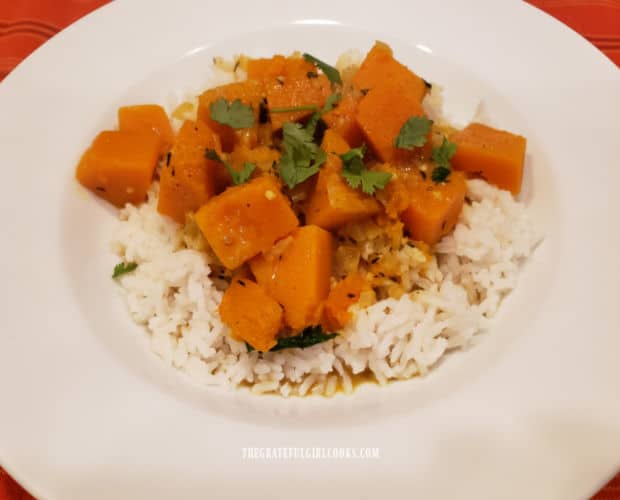 Butternut Squash Coconut Curry is served on top of steamed rice, in a white bowl.