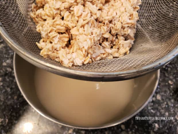 The water is strained off the soaked oats into a large bowl.