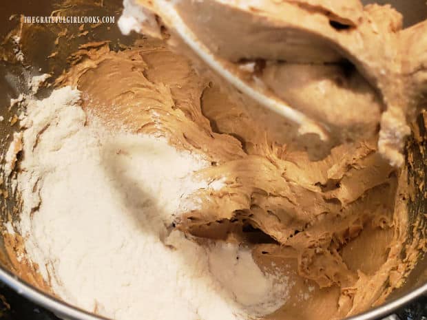 Flour, baking powder and salt are sifted then added to the cookie batter in mixing bowl.