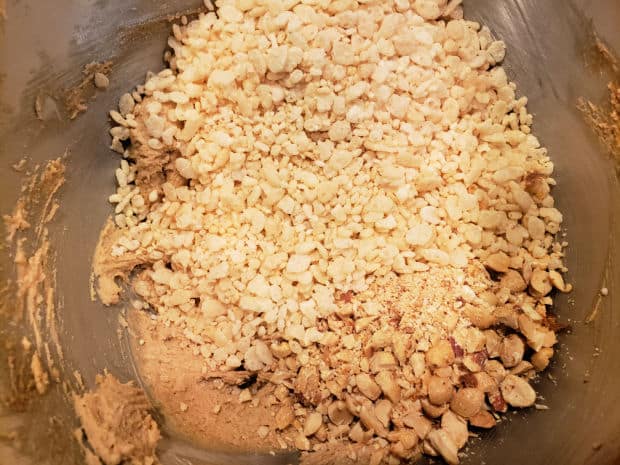 Puffed rice cereal and chopped peanuts are added to the cookie dough.