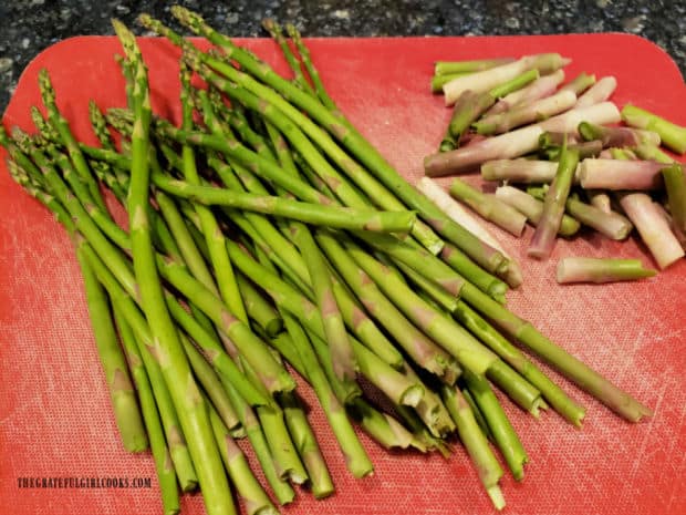 The woody ends of fresh asparagus are cut or snapped off.
