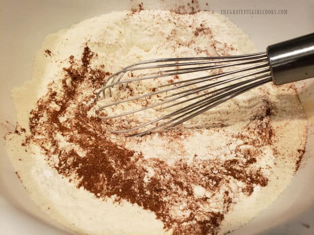 Flour, baking powder, salt and cinnamon are whisked together in large bowl.