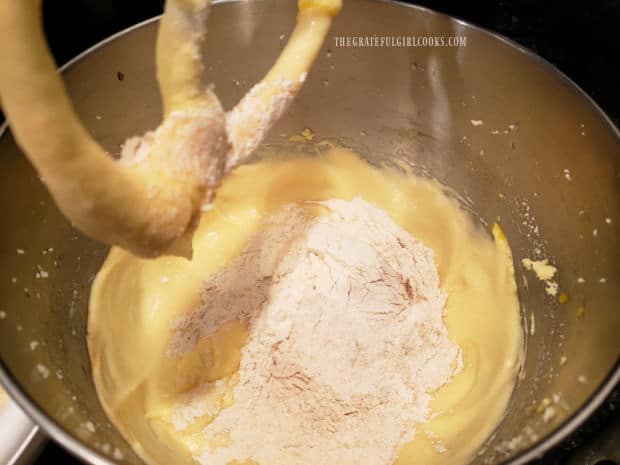 Flour and other dry ingredients are added to the batter for the snickerdoodle bread and combined.