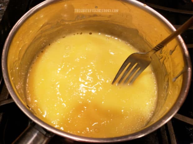 Milk and egg thickener is heated in saucepan for two minutes to cook.
