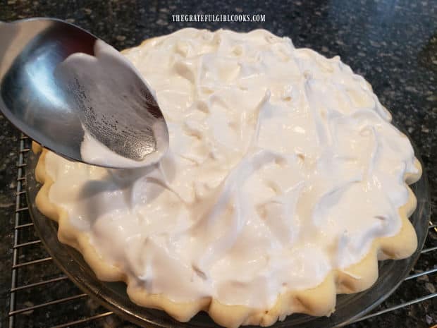 Decorative dollops of meringue are formed with a spoon on top of pie.