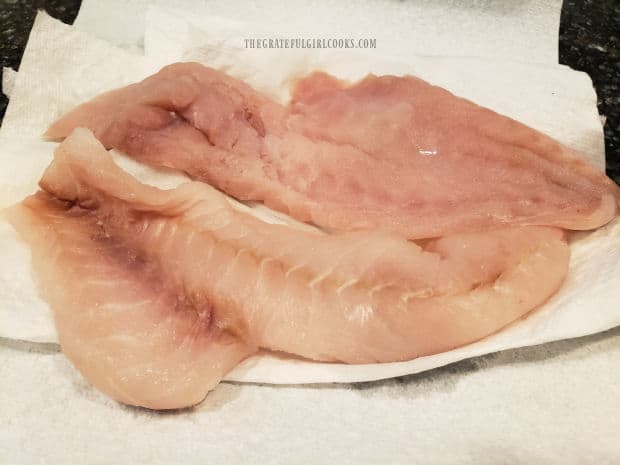 Rockfish fillets are patted dry with paper towels before seasoning.