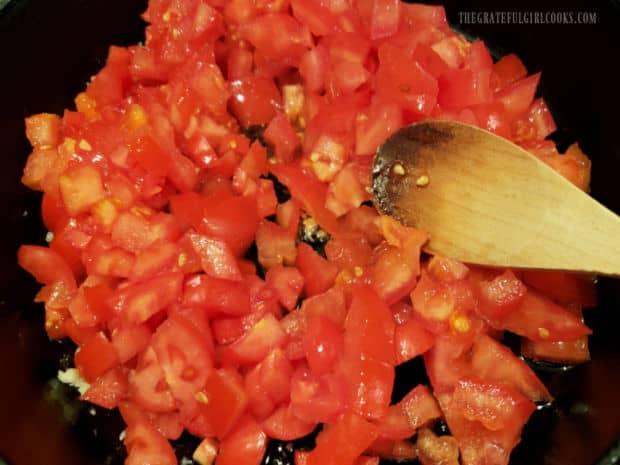 Diced tomatoes, garlic and spices are cooked in a large skillet to make a sauce.