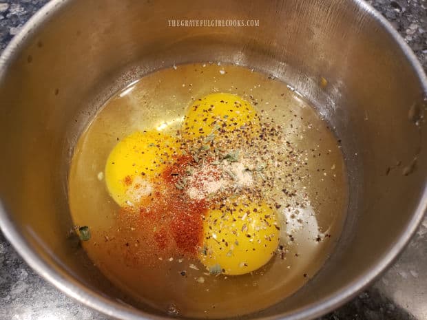 Eggs, oregano, garlic powder, cumin, paprika and salt and pepper are combined in a bowl.