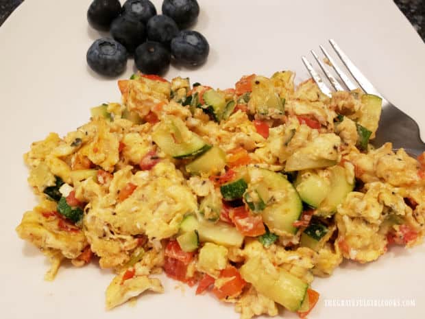 The TexMex veggie egg scramble on a plate, with blueberries above it.