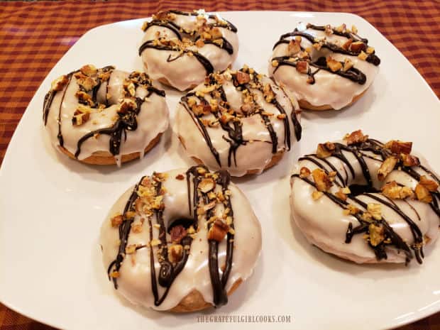 A serving plate with six baked banana doughnuts on it, ready to eat!