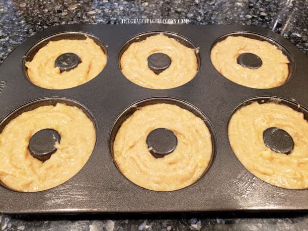 The baked banana doughnut batter is divided evenly into six wells in doughnut pan.