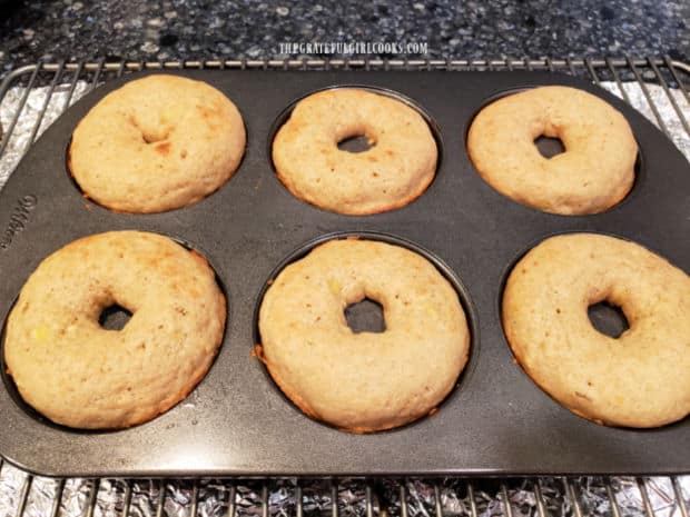 After baking, the banana doughnuts cool in the pan on a wire rack before removing.