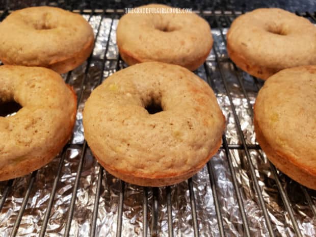 Baked banana doughnuts cooling on a wire rack.