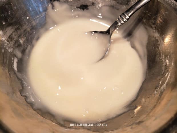 A glaze is made with powdered sugar, milk and vanilla to frost the baked doughnuts.