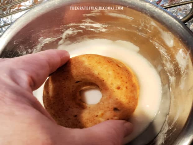 Each doughnut is placed in the glaze to fully coat the top of each one.