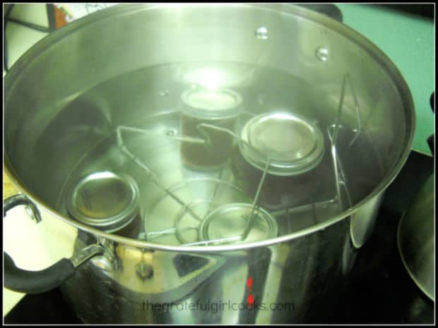 Jars of jam being processed in a water bath canner.