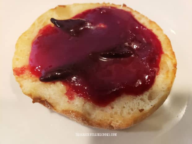 A toasted English muffin, covered with Italian Plum Jam, and ready to enjoy.